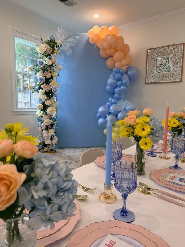 Blue floral arch with balloon garland and table styling